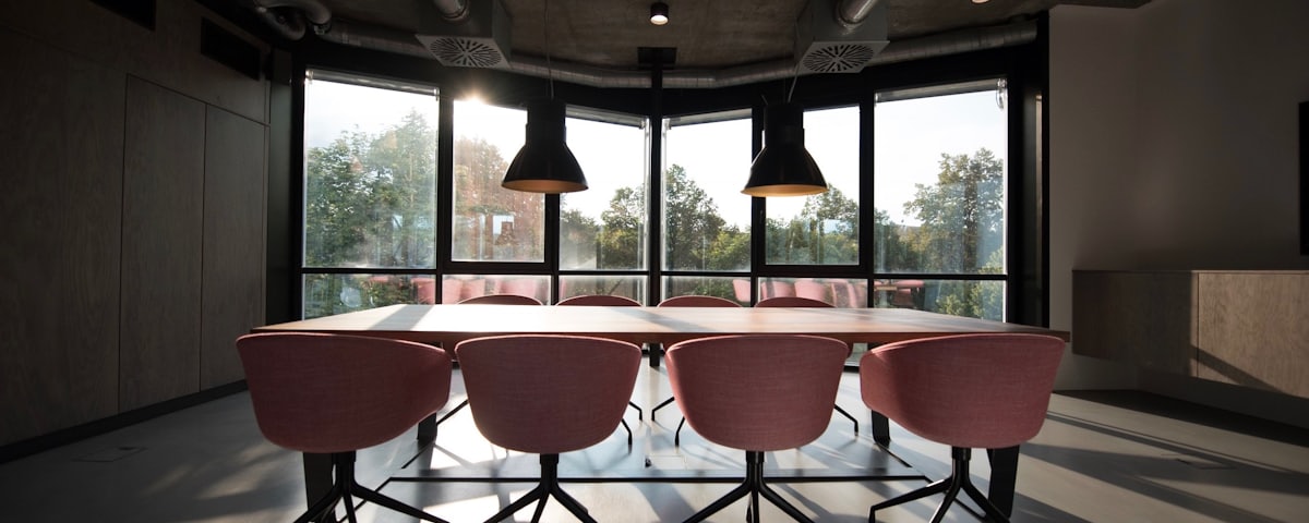 A quiet boardroom with a long table, lit by evening light