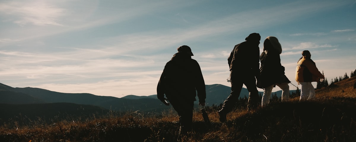 A family walking up a hillside together toward the light